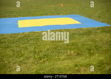 Tappetino da allenamento sportivo. Rivestimento morbido per l'esercizio fisico in parcheggio. Parco giochi per gli sport sul prato verde. Lezioni nel parco. Foto Stock