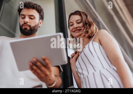 Un team diversificato di professionisti che collabora su strategie di marketing, esamina i report e collabora per il successo aziendale. Foto Stock