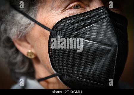 La donna indossa una maschera facciale N95 del tipo in uso comune a causa dei tentativi di controllare la diffusione della COVID-19. Foto Stock