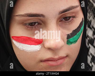 Diyarbakir, Turchia. 15 ottobre 2023. Una donna è vista con il suo volto dipinto nei colori della bandiera palestinese durante un raduno in solidarietà con la Palestina a Station Square a Diyarbakir. Israele ha protestato in una manifestazione a sostegno dell'operazione al-Aqsa Flood, organizzata dal Partito della causa libera (HUDA-PAR) a Diyarbakir, la città con la più grande popolazione curda della Turchia. Credito: SOPA Images Limited/Alamy Live News Foto Stock