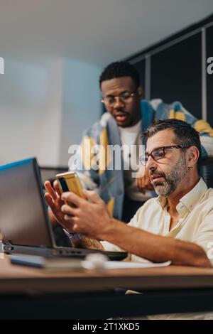 I professionisti aziendali multiculturali collaborano in una moderna sala riunioni, supportandosi reciprocamente per ottenere una crescita dei profitti e progetti di successo. Foto Stock