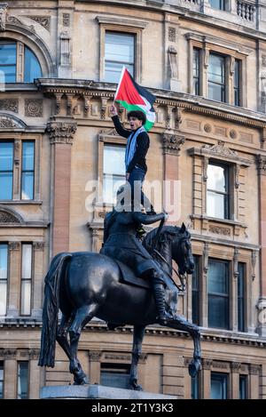 Protesta per la Palestina dopo l'escalation dell'azione militare nella Striscia di Gaza, conflitto tra Israele e Hamas. Manifestante sulla statua equestre di Carlo i Foto Stock