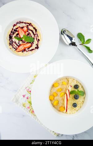 porridge con fragole, marmellata di menta e frutti di bosco in un piatto bianco, vista dall'alto Foto Stock