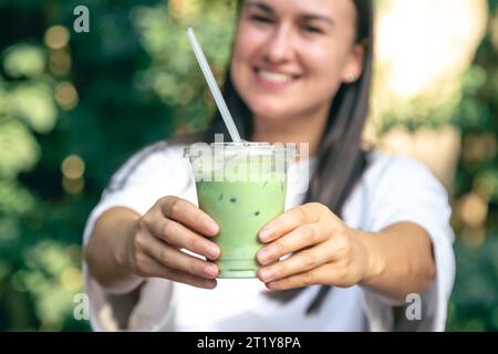 Tè verde freddo con latte in mano. Foto Stock