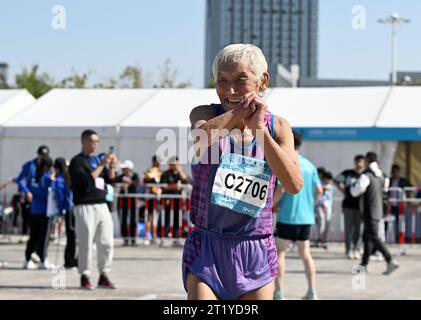 (231016) -- TIANJIN, 16 ottobre 2023 (Xinhua) -- Liu Runlong saluta altri corridori dopo la maratona di Tianjin del 2023 a Tianjin, il 15 ottobre 2023. Liu Runlong, 72 anni, è un appassionato di maratona. Ha partecipato alla prima maratona tenutasi a Tianjin nel 1981. Liu ha perso la mano destra in un incidente sul lavoro nel 1996. La disabilità fisica non gli ha impedito di correre. Liu ha partecipato a molte gare di maratona a Pechino, Dalian, Xiamen e in altre città della Cina. Ogni mattina alle quattro, Liu iniziò a correre lungo il fiume Haihe. Correrò il più a lungo possibile. La maratona non è solo per i giovani Foto Stock