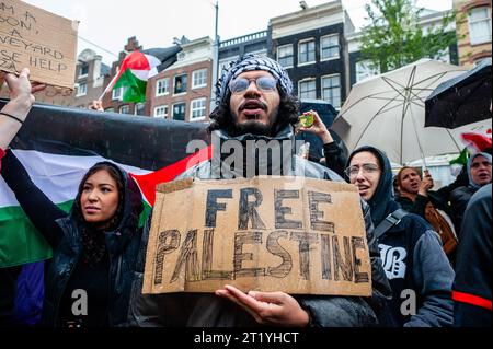 15 ottobre, Amsterdam. La comunità palestinese nei Paesi Bassi ha organizzato una marcia nel centro della città per condannare il governo di Israele ed esprimere solidarietà al popolo palestinese. Durante la manifestazione, circa 10.000 manifestanti hanno sventolato bandiere palestinesi e portato striscioni, inviando un potente messaggio di solidarietà a Gaza e al popolo palestinese. Foto Stock