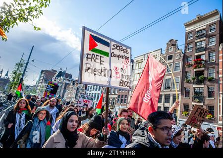 15 ottobre, Amsterdam. La comunità palestinese nei Paesi Bassi ha organizzato una marcia nel centro della città per condannare il governo di Israele ed esprimere solidarietà al popolo palestinese. Durante la manifestazione, circa 10.000 manifestanti hanno sventolato bandiere palestinesi e portato striscioni, inviando un potente messaggio di solidarietà a Gaza e al popolo palestinese. Foto Stock