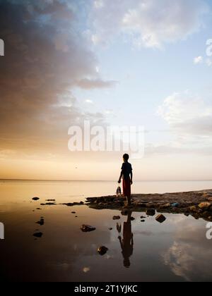 Un giovane ragazzo etiope tiene il suo pescato sulle rive del lago Langano, Etiopia. Foto Stock