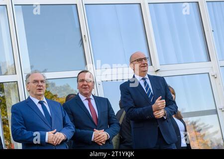 Holzdorf, Germania. 16 ottobre 2023. Reiner Haseloff (l-r, CDU), Ministro Presidente della Sassonia-Anhalt, Ministro della difesa tedesco Boris Pistorius (SPD) e Dietmar Woidke (SPD, Ministro Presidente del Brandeburgo) sono fianco a fianco di fronte ai quartieri degli ufficiali della base aerea di Holzdorf. Insieme ai ministri presidenti di Brandeburgo e Sassonia-Anhalt, Pistorius si informò del sito e dei grandi progetti in corso. Credito: Klaus-Dietmar Gabbert/dpa/Alamy Live News Foto Stock