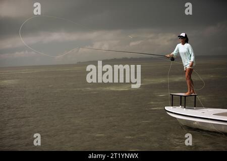 Donna che pesca dal motoscafo Foto Stock