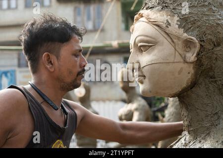 Artigiano impegnato nella preparazione di Durga Idols davanti a Durga Puja in India Foto Stock