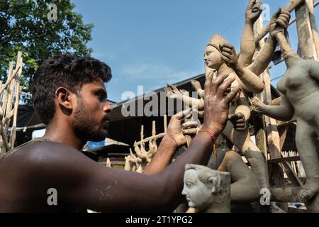 Artigiano impegnato nella preparazione di Durga Idols davanti a Durga Puja in India Foto Stock