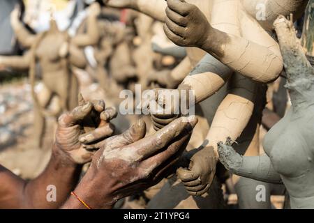 Artigiano impegnato nella preparazione di Durga Idols davanti a Durga Puja in India Foto Stock