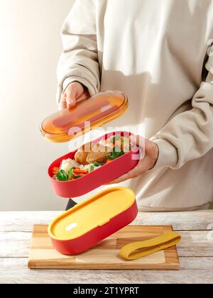 Donna che prepara cibo per suo figlio a tavola in cucina, primo piano. H Foto Stock