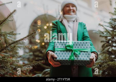 Donna anziana con molti regali Chrismtas nelle sue mani. Foto Stock