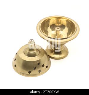una lampada diya con supporto per incenso divino di forma unica realizzata in metallo d'ottone dorato utilizzato per celebrazioni religiose isolata su uno sfondo bianco Foto Stock