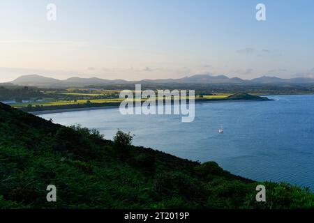 Tra i lussureggianti pendii ricoperti di bracken del promontorio di Llanbedrog, mentre il sole serale si cala sopra la nebbiosa campagna gallese. Foto Stock