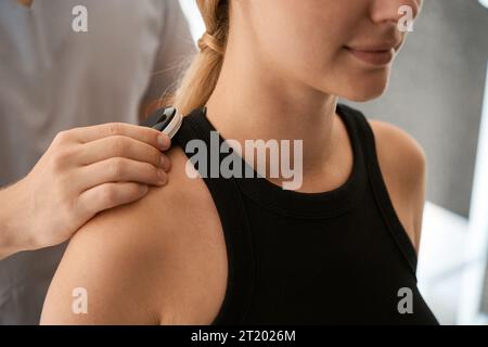 Uno specialista conduce una sessione di terapia hardware in un centro benessere Foto Stock