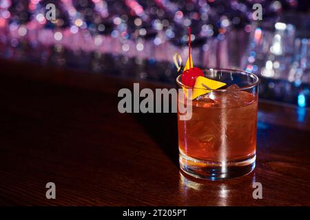 elegante negroni dissetante decorato con ciliegia da cocktail sul bancone del bar, concetto Foto Stock