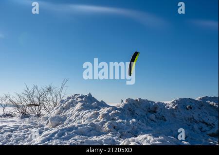 Snowkiting sul Wasserkuppe in Germania in una splendida giornata invernale con cieli azzurri e tanta neve Foto Stock