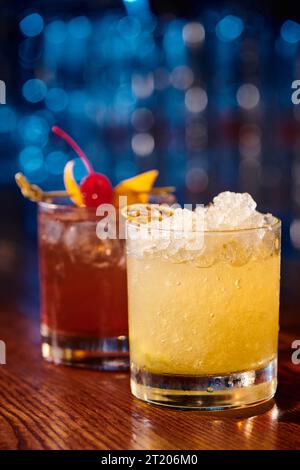 esotici caipirinha e negroni guarniti con ghiaccio e frutta con bar sullo sfondo, concetto Foto Stock