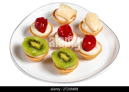 Tartarughe di frutta isolate su sfondo bianco. Tartarughe di fragola, banana e kiwi su un piatto. snack dolci Foto Stock