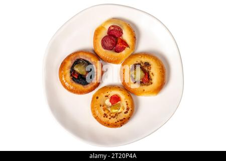 Piccole varietà di pizza. mini pizze con salsiccia, sottaceti, pomodori, mozzarella, prezzemolo, verdi isolati su sfondo bianco. Vista dall'alto Foto Stock