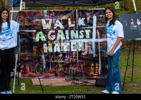 Due ragazze hanno un grande segno con un dipinto artistico e le parole "cammina contro l'odio" al raduno Acton-Boxborough contro l'antisemitismo. Foto Stock