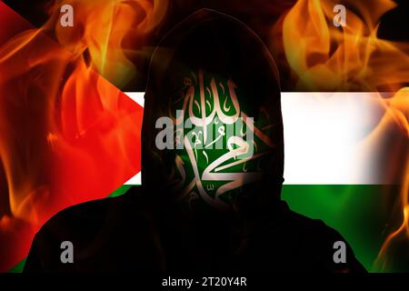 Terrorista incognito sullo sfondo del fuoco di Flag Palestine. Hamas tra Israele e Palestina. Israele guerra in Palestina. Crisi mondiale in Medio Oriente Foto Stock