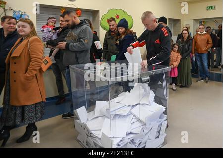 Varsavia, Polonia. 15 ottobre 2023. Un uomo lancia i voti in un seggio elettorale a Varsavia, in Polonia, 15 ottobre 2023. Il partito polacco per la legge e la giustizia (PiS) ha preso il comando nelle elezioni parlamentari di domenica con il 36,8% dei voti, secondo un sondaggio di uscita. Crediti: Aleksy Witwicki/Xinhua/Alamy Live News Foto Stock