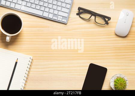 scrivania in legno con computer portatile, smartphone e altre attrezzature da lavoro con una tazza di caffè. Vista superiore con spazio di copia per l'immissione del testo. Area di lavoro di progettazione o Foto Stock
