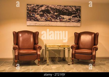 Le due eleganti poltrone in pelle in uno spazio abitativo contemporaneo Foto Stock
