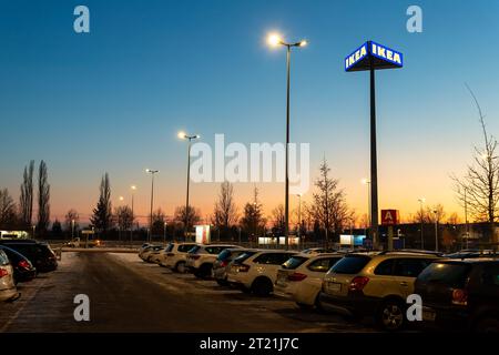 Magdeburg, Germania - 13 dicembre 2022: Cartello con il logo Big IKEA sul pilastro presso il parcheggio dello showroom del punto vendita al dettaglio, in un caldo tramonto blu sera Foto Stock