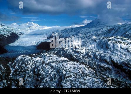 Veduta aerea di un ghiacciaio sul lato ovest inferiore di Cook Inlet, Alaska. La fotografia evidenzia le dimensioni e la posizione del ghiacciaio all'interno del terreno montuoso. I ghiacciai sono una caratteristica fondamentale dell'aspro paesaggio dell'Alaska, modellato sia dalla geografia fisica che dalle condizioni climatiche. Foto Stock