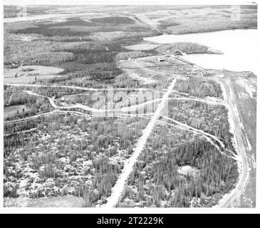 Vista aerea storica del lago Hood, di Anchorage, Alaska, con strutture per aerei, piste, e il paesaggio naturale circostante. Foto Stock