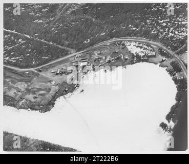 Fotografia aerea del lago Hood, Anchorage, Alaska, che mostra le prime strutture aeroportuali, gli aerei sull'acqua e le aree di trasporto circostanti. Foto Stock