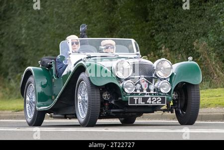 Bicester, Oxon., Regno Unito - 8 ottobre 2023: 2010 Green SSE KIT CAR SS100 AUTO d'epoca che guida su una strada di campagna inglese. Foto Stock