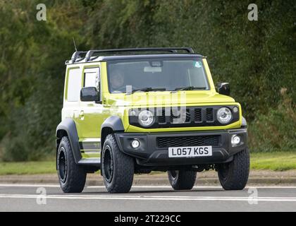 Bicester, Oxon., UK - 8 ottobre 2023: 2019 auto d'epoca gialla Suzuki Jimny che guida su una strada di campagna inglese. Foto Stock