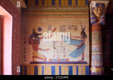Antico murale egiziano raffigurante due figure, una con la testa di uno sciacallo che rappresenta il dio Anubi e l'altra con la testa di una mucca Foto Stock