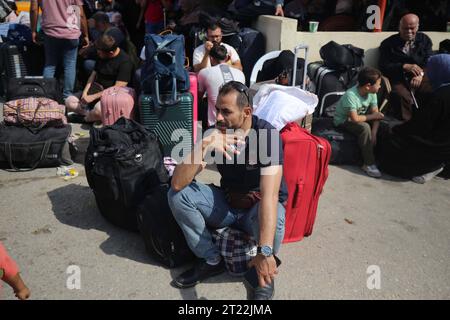 I palestinesi, alcuni con passaporti stranieri che sperano di attraversare l'Egitto e altri in attesa di aiuti, attendono i palestinesi di Rafah, altri con passaporti stranieri che sperano di attraversare l'Egitto e altri in attesa di aiuti, aspettano il passaggio di Rafah nella striscia meridionale di Gaza, il 16 ottobre 2023. Il bilancio delle vittime degli scioperi israeliani sulla Striscia di Gaza è salito a circa 2.750 dall'attacco mortale di Hamas al sud di Israele la settimana scorsa, il ministero della salute di Gaza ha dichiarato il 16 ottobre. Anche circa 9.700 persone sono rimaste ferite mentre Israele ha continuato la sua campagna aerea appassita contro obiettivi nell'enclave costiera palestinese, Foto Stock