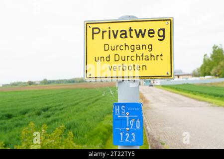 C'è un cartello giallo vicino alla strada con l'iscrizione - l'accesso e il viaggio sulla strada privata sono vietati. L'iscrizione sul cartello è in GE Foto Stock