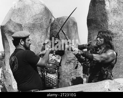 Il regista JOHN MILIUS BEN DAVIDSON e ARNOLD SCHWARZENEGGER sul set di CONAN IL BARBARO personaggio del 1982 creato da ROBERT e> HOWARD Costume Design JOHN BLOOMFIELD Music BASIL POLEDOURIS Universal Pictures Foto Stock