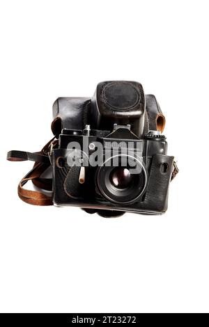 Fotocamera reflex vintage in una vecchia custodia protettiva in pelle, usurata al momento dell'utilizzo, su sfondo bianco, primo piano, scatto verticale, messa a fuoco fluttuante, lieve Foto Stock