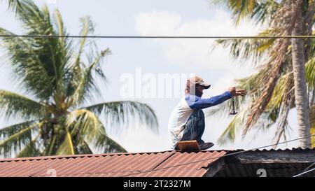 Pinrang Indonesia, 16 ottobre 2023: Fotografia di paesaggi, falegnami sostituiscono un vecchio tetto di latta, Asia Indonesia Foto Stock