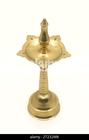 vecchia lampada a stoppino d'olio d'epoca o vilakku in ottone dorato utilizzato nei templi e nei luoghi di culto tradizionalmente isolati su uno sfondo bianco Foto Stock