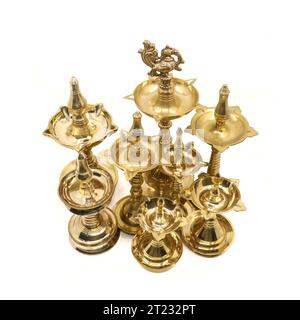 una collezione di rari manufatti antichi a lampade a olio di diverse dimensioni realizzati in forme tradizionali e con design in ottone dorato isolato Foto Stock