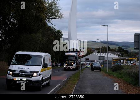 Selkirk, Regno Unito. 16 ottobre 2023. Una pala di turbina eolica sulla strada per una nuova installazione vicino a Hawick, un convoglio stradale ha fatto il viaggio da un pennarello sulla A68 vicino a St Boswells a Selkirk sulla A699, poi ha navigato su un bivio scomodo alla A7, Selkirk, e si dirige a sud sulla A7, si fermerà di notte prima di spostarsi verso la sua destinazione al parco eolico Pines Burn. Si tratta di un progetto onshore di 36 MW che non prevede sussidi per l'energia eolica, situato nella tenuta di Harwood vicino al Bonchester Bridge e a Hawick nei confini scozzesi. ( Credit: Rob Gray/Alamy Live News Foto Stock