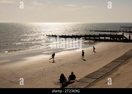 Personaggi sagomati che giocano a cricket sulla spiaggia al mare Foto Stock