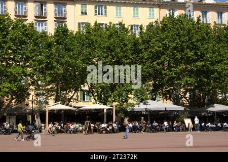 I clienti riempiono i caffè sulla piazza alberata Saint Nicolas a Bastia, Corsica. Foto Stock