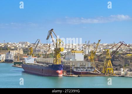 La Valletta, Malta - 6 agosto 2023: Grande petroliera in bacino di carenaggio per riparazioni con un'altra petroliera ormeggiata nel porto della città Foto Stock